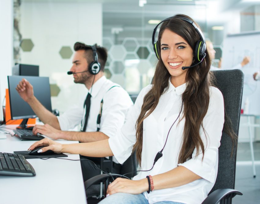 Beautiful smiling woman with headphones looking at camera at office